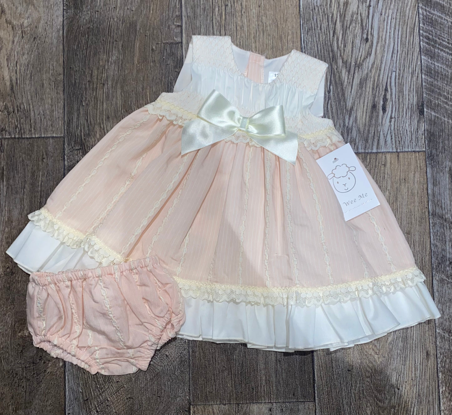 Peach and cream baby occasion dress with lace trim and matching knickers