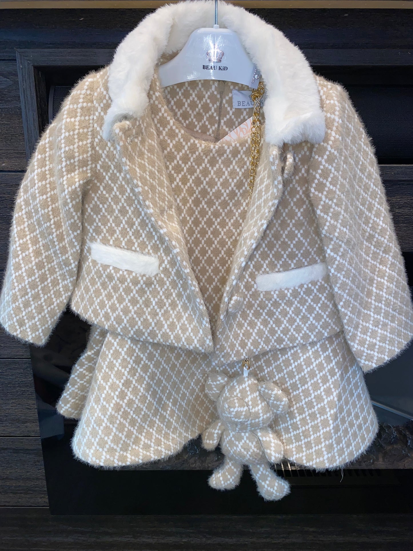 beige dress & jacket with cream trim on a dark background