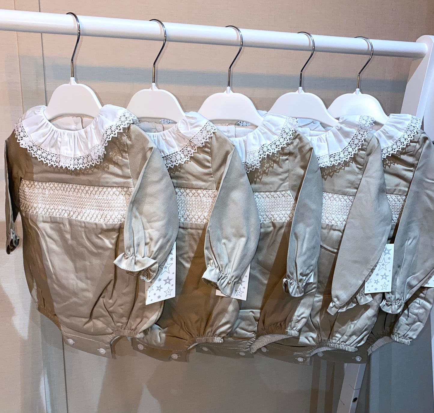 Elegant neutral baby outfit with lace collar and smocking