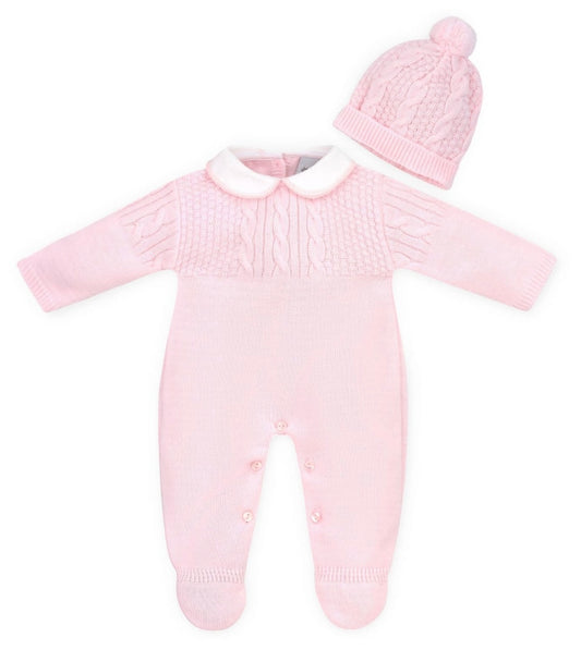 Pink knitted baby outfit with a hat on a white background