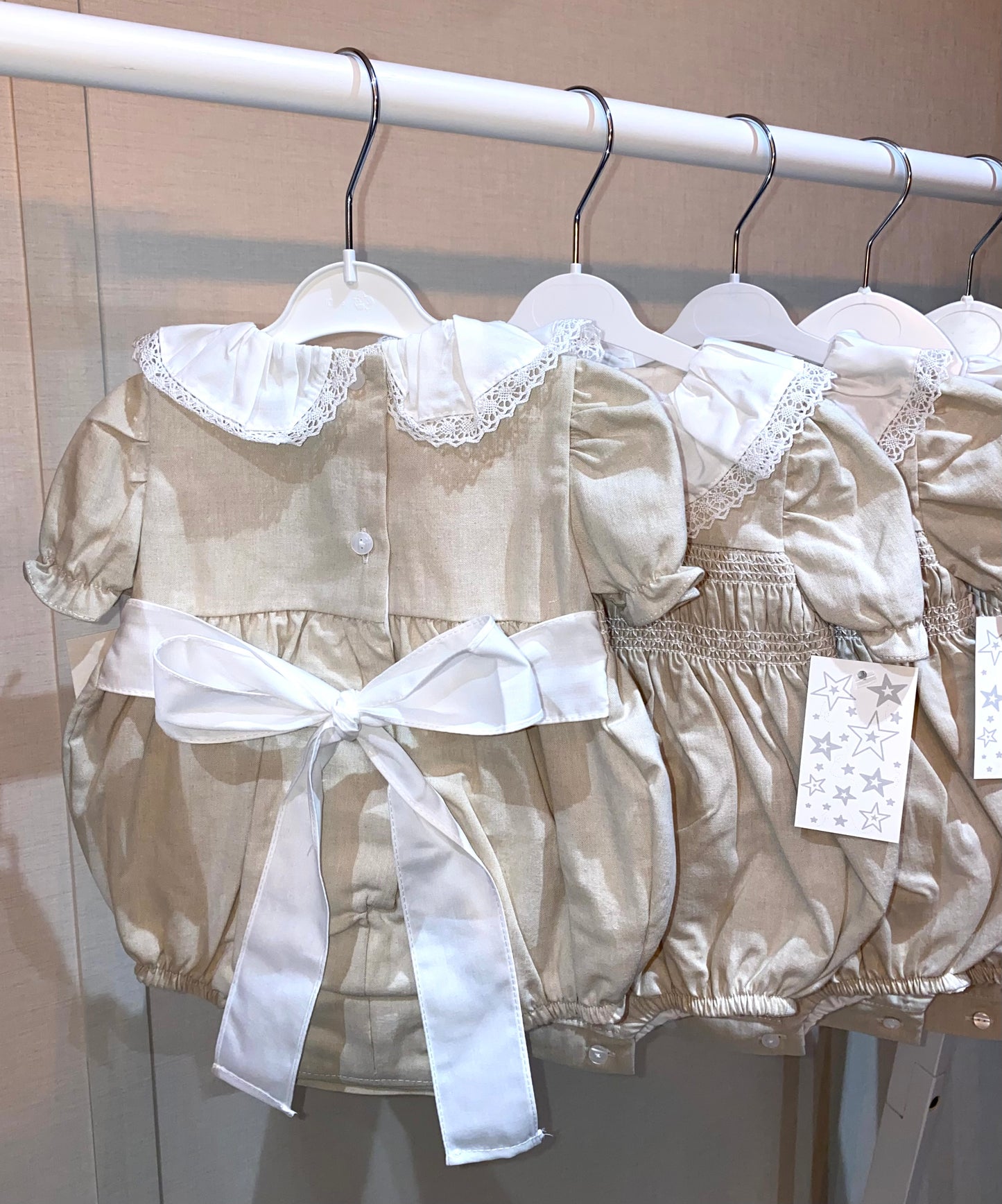 Baby girls beige baby outfit with lace details and a white bow 