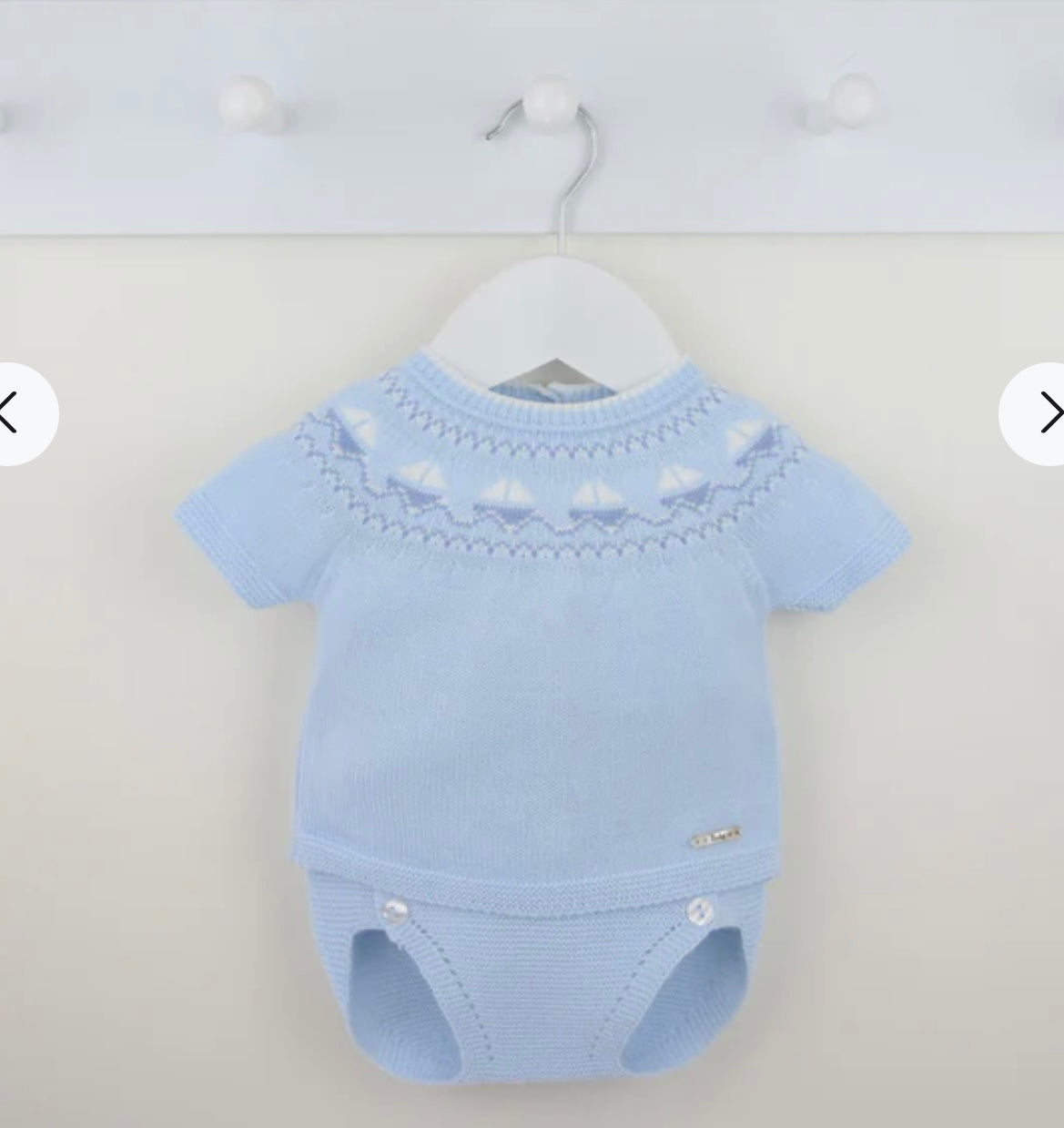 Blue baby boys outfit on a hanger against a light gray background