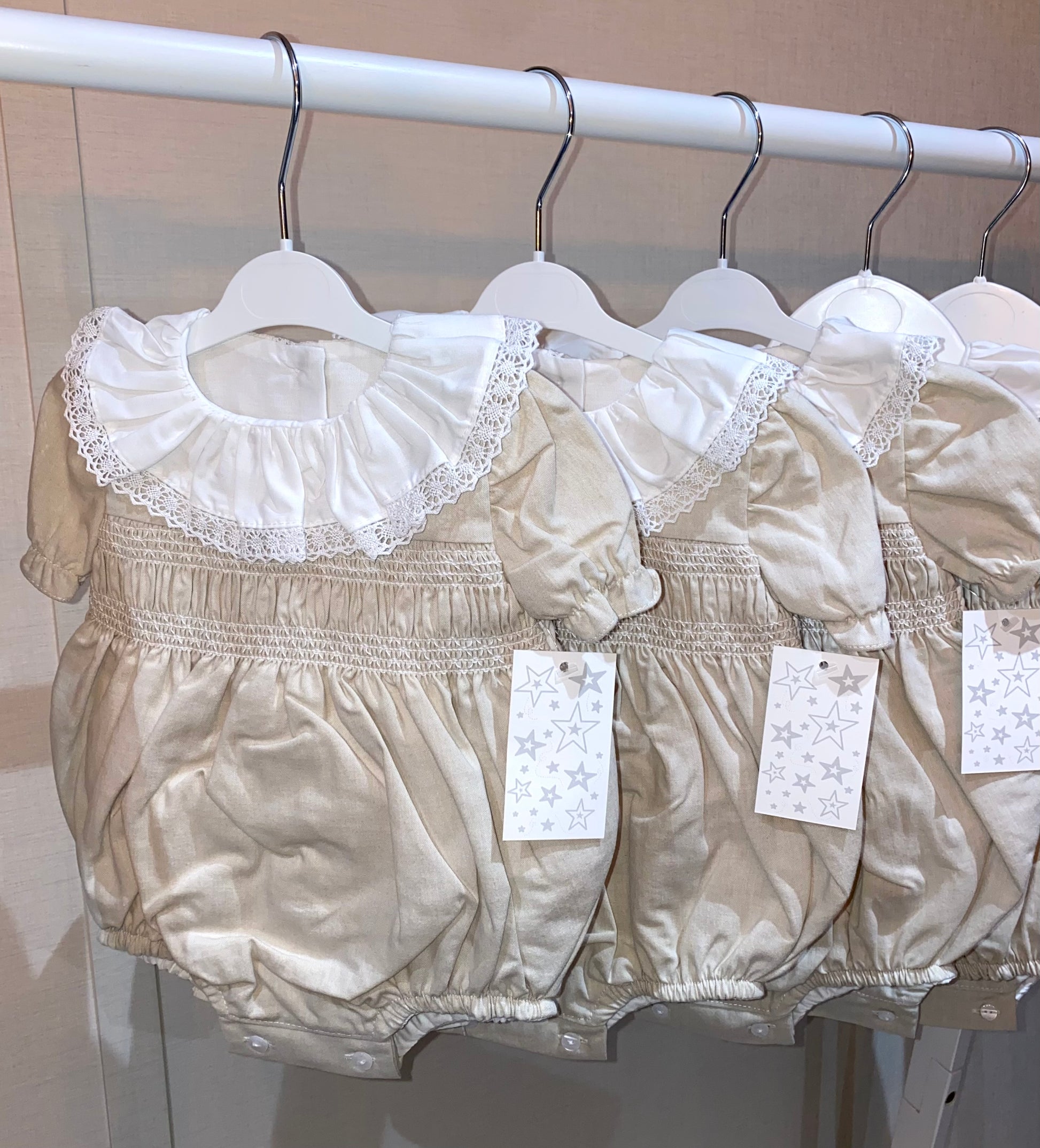 Luxury baby romper with lace collar and smocked chest detail