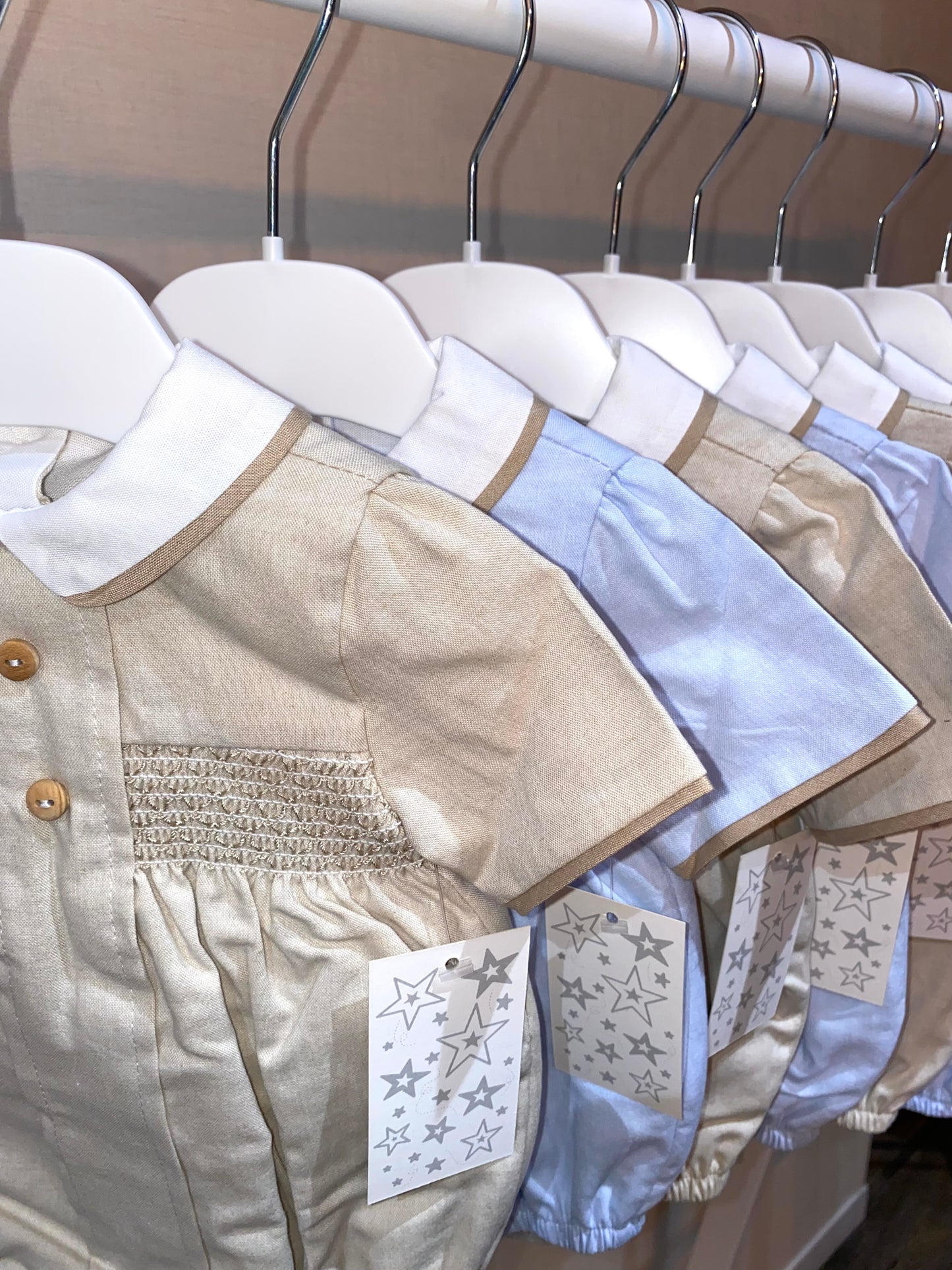 Close up of the smocked details on the beige baby romper