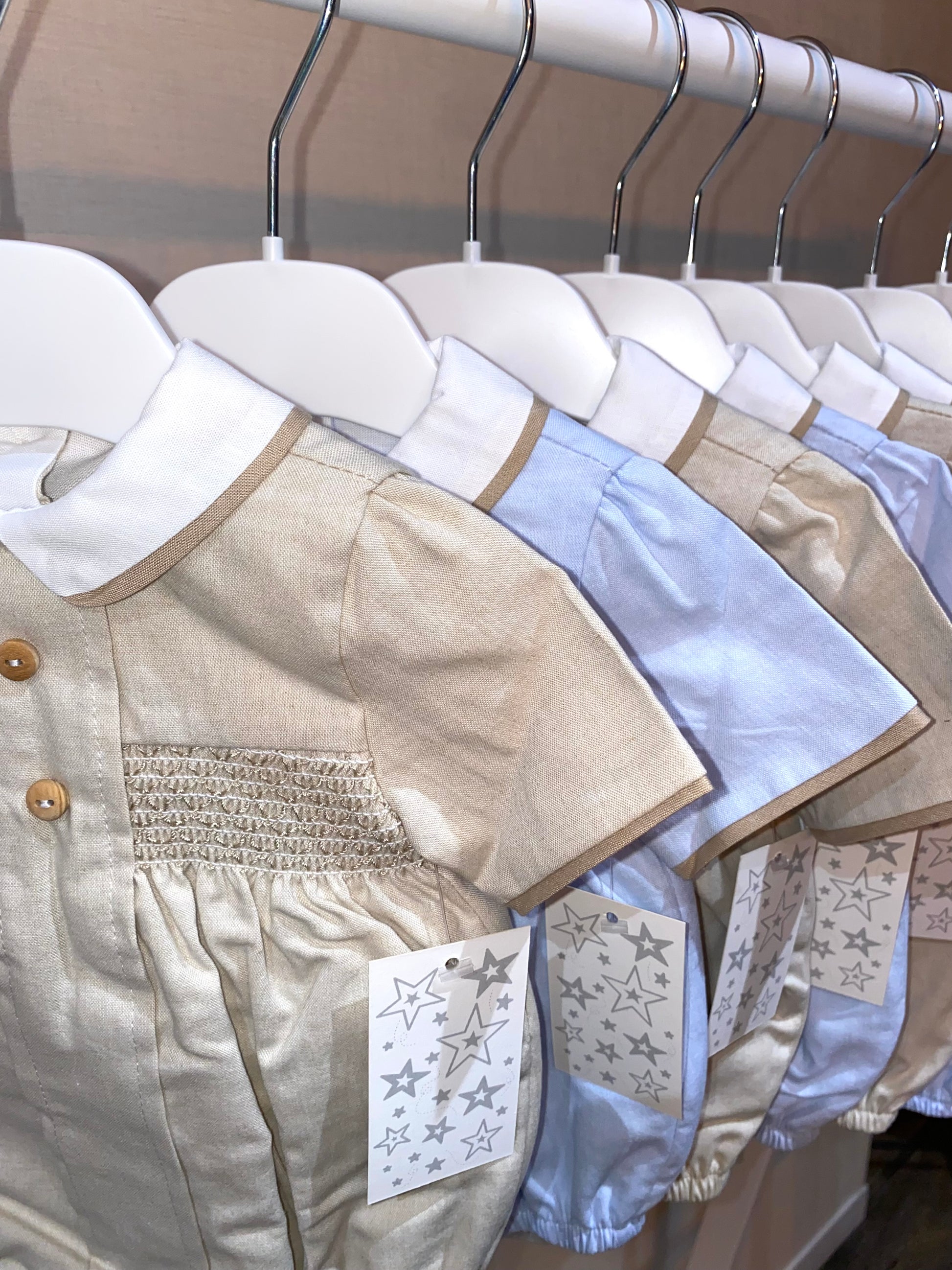 Close up of the smocked details on the beige baby romper